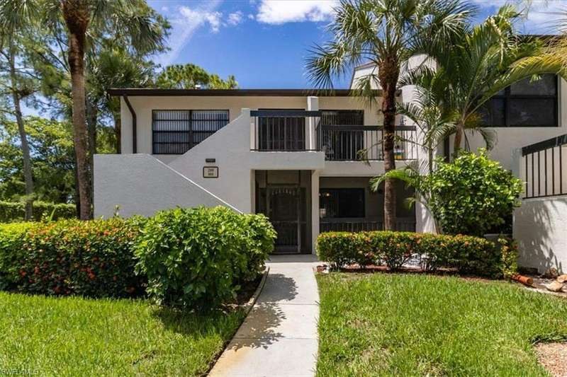 View of front of house with a balcony and a front lawn