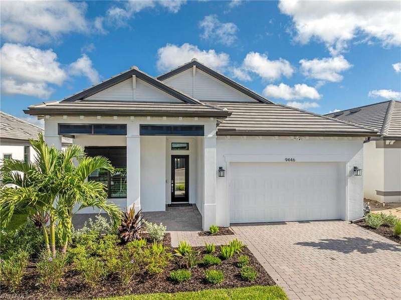 View of front of property featuring an attached garage, decorative driveway, and stucco siding