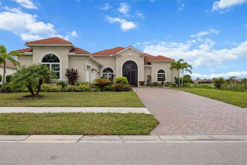 Mediterranean / spanish-style home with stucco siding, a front lawn, a tile roof, decorative driveway, and a garage