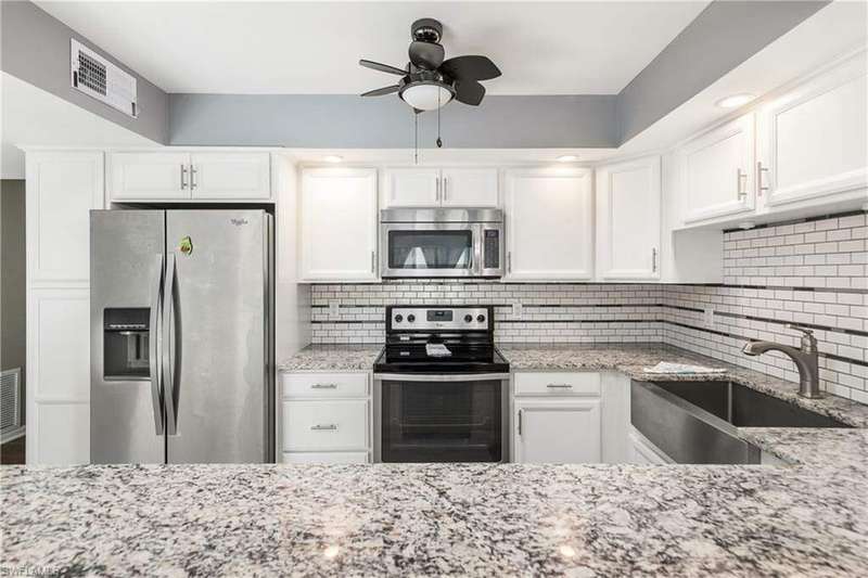 Kitchen featuring stove, tasteful backsplash, stainless steel dishwasher, sink, and white cabinetry