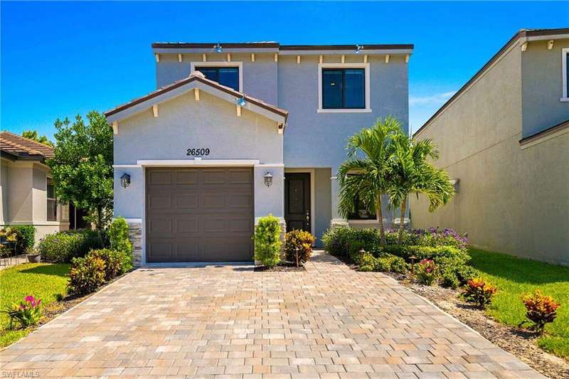 View of front of house featuring a garage, stucco siding, and decorative driveway