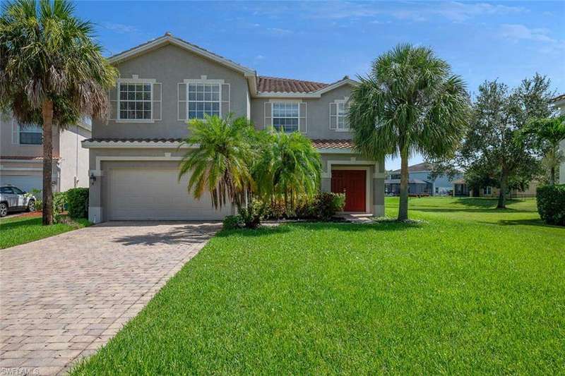 View of front facade featuring a garage and a front lawn