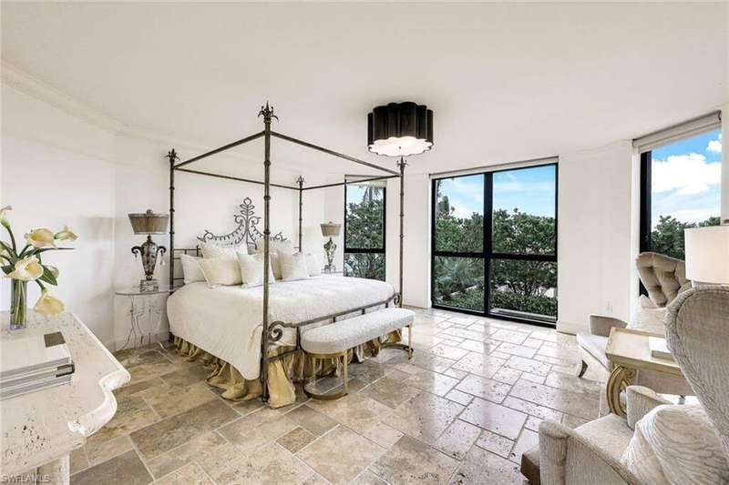 Primary Bedroom with ceiling to floor windows with shades to let the nature inside