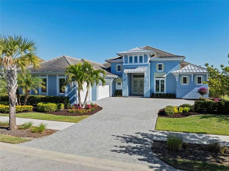 View of front of home featuring french doors, a front lawn, and a garage