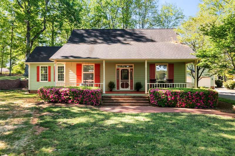 Charming curb appeal with brick walkway, blooming azaleas, and a wide front porch perfect for relaxing.