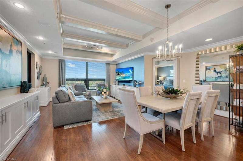 Dining space with beamed ceiling, dark hardwood / wood-style flooring, ornamental molding, and a chandelier