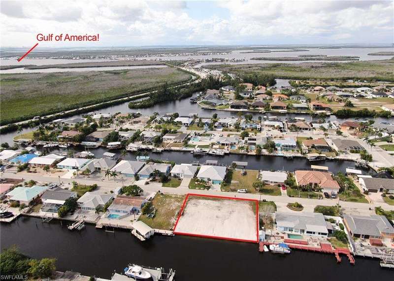 Aerial view of residential area with property parcel outlined and a large body of water