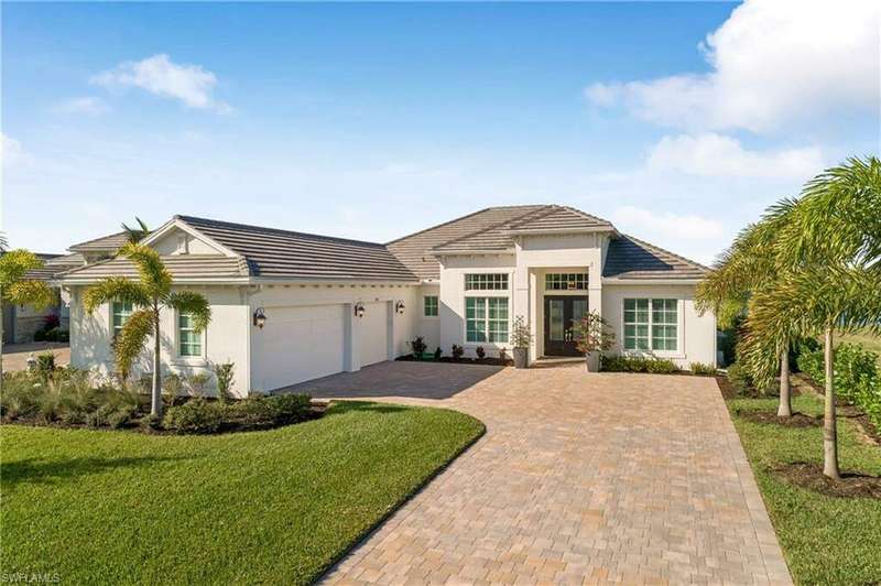 View of front of house with a front lawn, a garage, and french doors