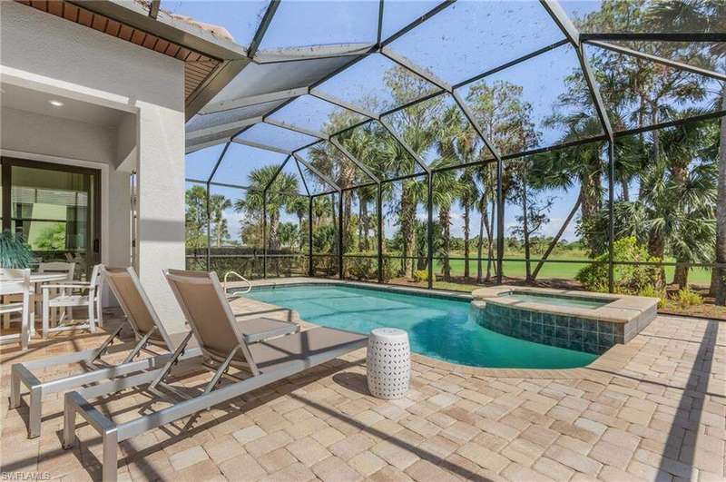 View of pool featuring an in ground hot tub, a patio area, and glass enclosure