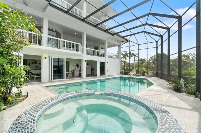 View of pool with a pool with connected hot tub, a patio area, a ceiling fan, and glass enclosure
