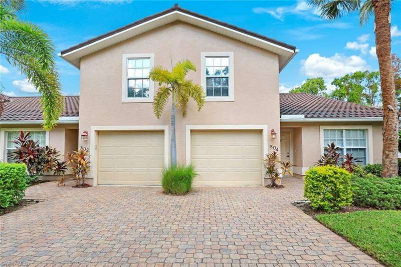 Front view of property with paver driveway and an attached garage