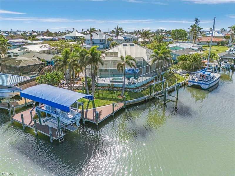 Aerial of canal side of the property.  The covered wrap-around 10K# boat lift and composite dock, and a 5K# lift, plus room for a sailboat!