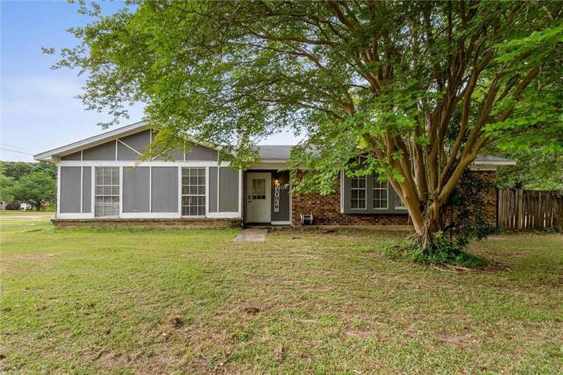 View of front of home with fence, brick siding, and a front yard