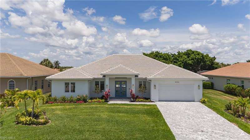 View of front of property with a front yard, stucco siding, decorative driveway, an attached garage, and a tiled roof