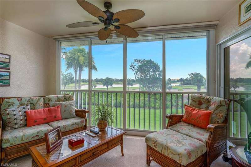 Sunroom / solarium featuring a water view, plenty of natural light, and view of golf course