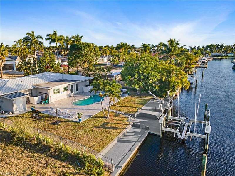Dock area featuring a lawn, a water view, and a patio area