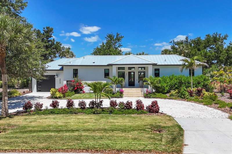 The home’s front is elegantly nestled beyond a circular driveway, framed by meticulously maintained and eye-catching landscaping.