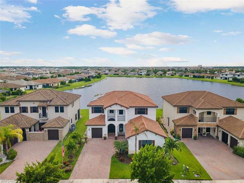 View of front of house featuring a residential view, stucco siding, a water view, decorative driveway, and a tiled roof
