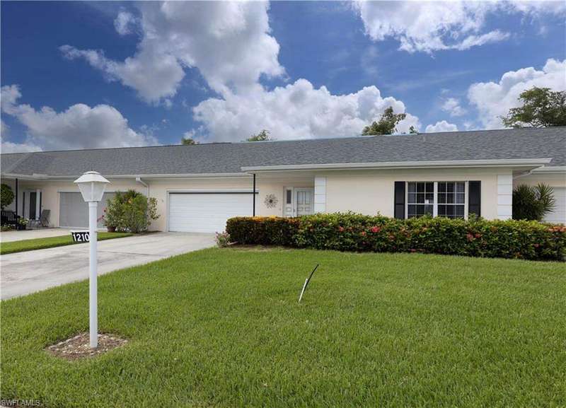 Ranch-style house featuring a garage and nice front yard