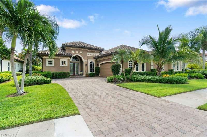 Mediterranean / spanish home featuring a garage and a front lawn