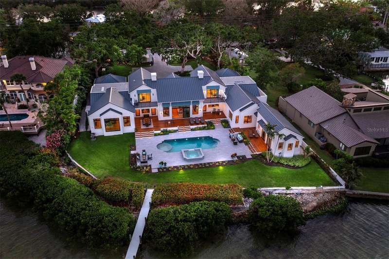 Extensive landscape lighting showcases the property beautifully at twilight.