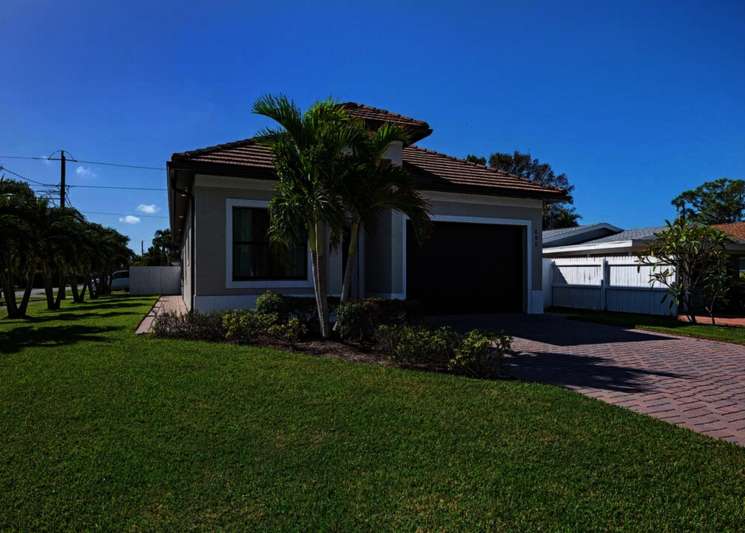 View of front of property with a garage and a front lawn