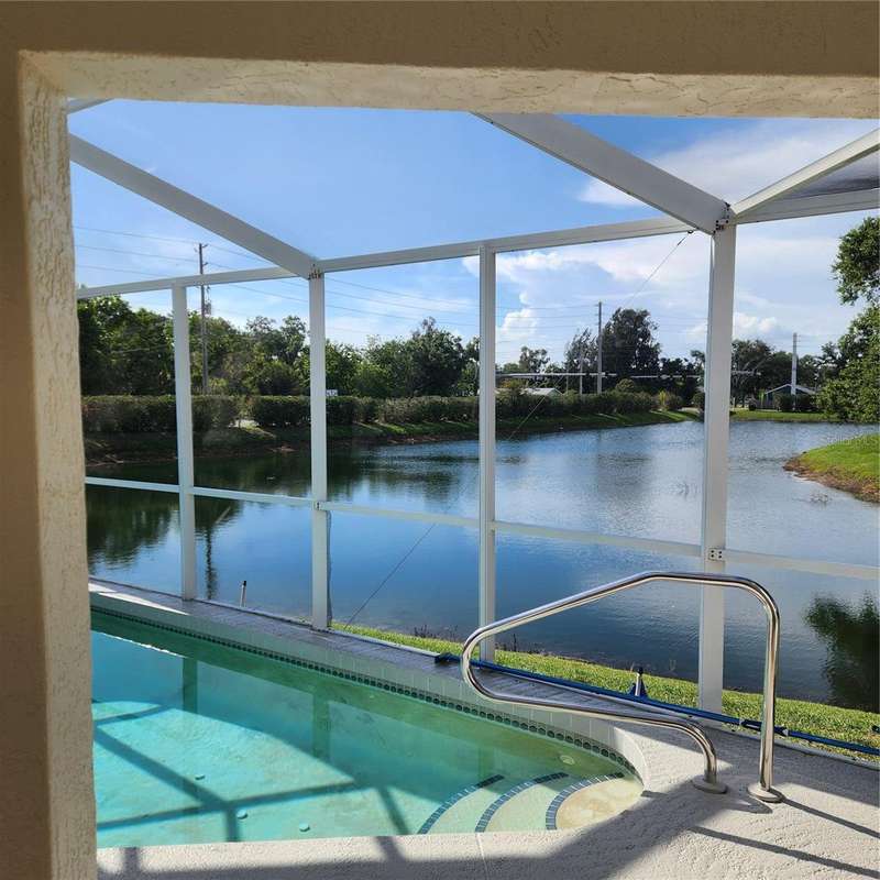 Screen enclosed pool overlooking pond out back
