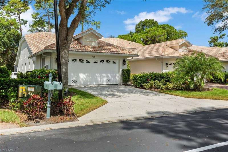 View of front of house featuring stucco siding, concrete driveway, and a tile roof