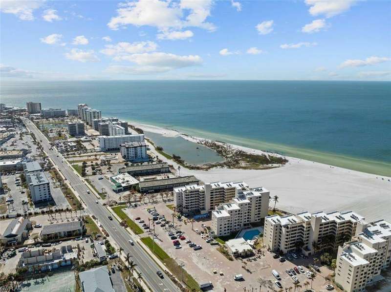 Aerial view featuring a water view and a beach view