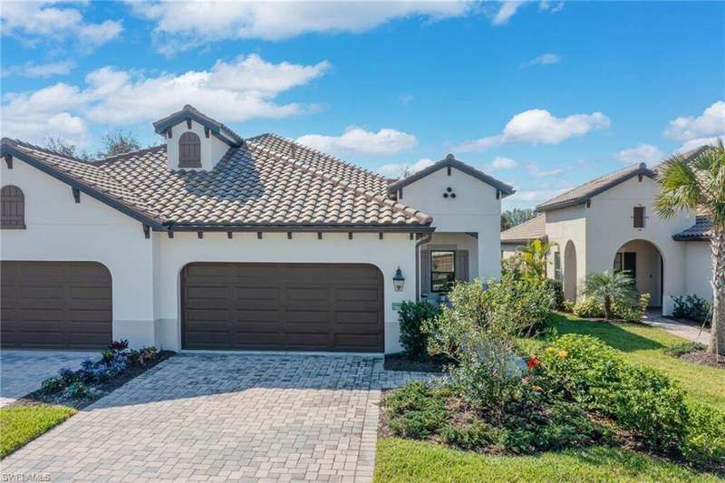 Mediterranean / spanish house with a garage, decorative driveway, a tile roof, and stucco siding
