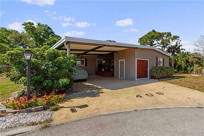 View of front of property with a carport and concrete driveway