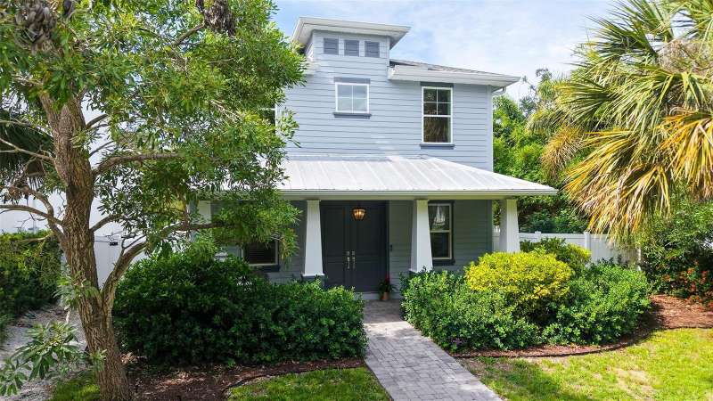 THE LARGE CORNER LOT HAS LUSH VEGETATION