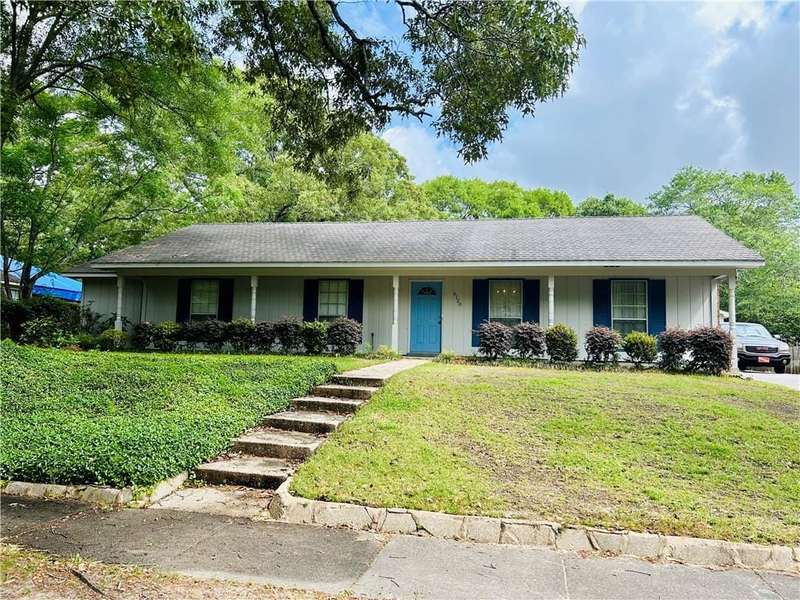 Ranch-style home with a front yard, board and batten siding, and covered porch