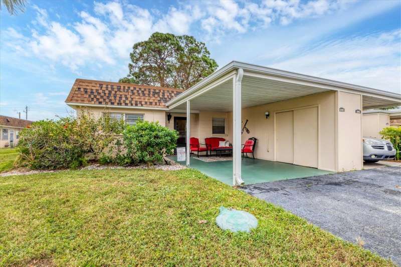 Front of villa with attached carport and storage closet