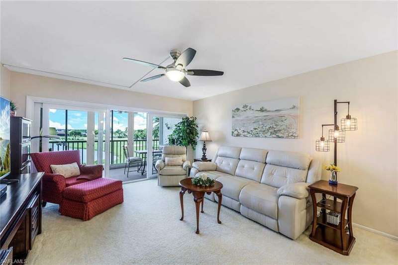 Carpeted living room with ceiling fan