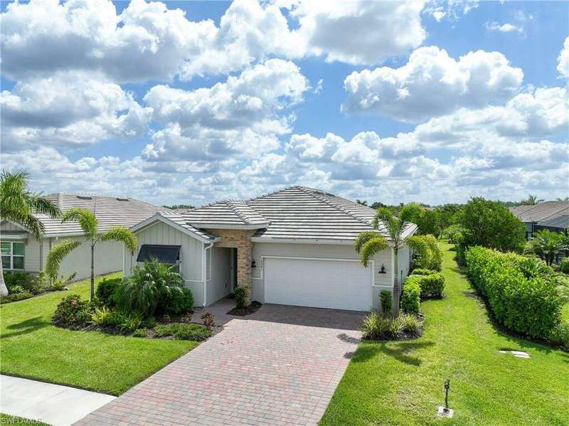 Single story home featuring a garage, a front lawn, decorative driveway, and a tile roof