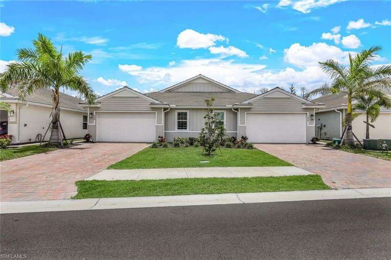 Ranch-style home featuring a garage and a front lawn