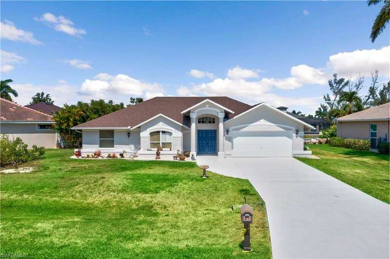 Ranch-style house featuring a front yard and a garage