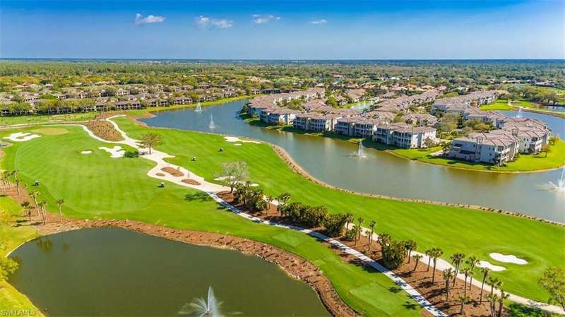 Aerial view of residential area with a golf course and a nearby body of water