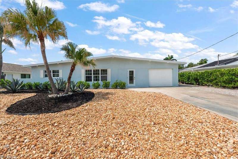 Ranch-style house featuring concrete driveway, a garage, and stucco siding
