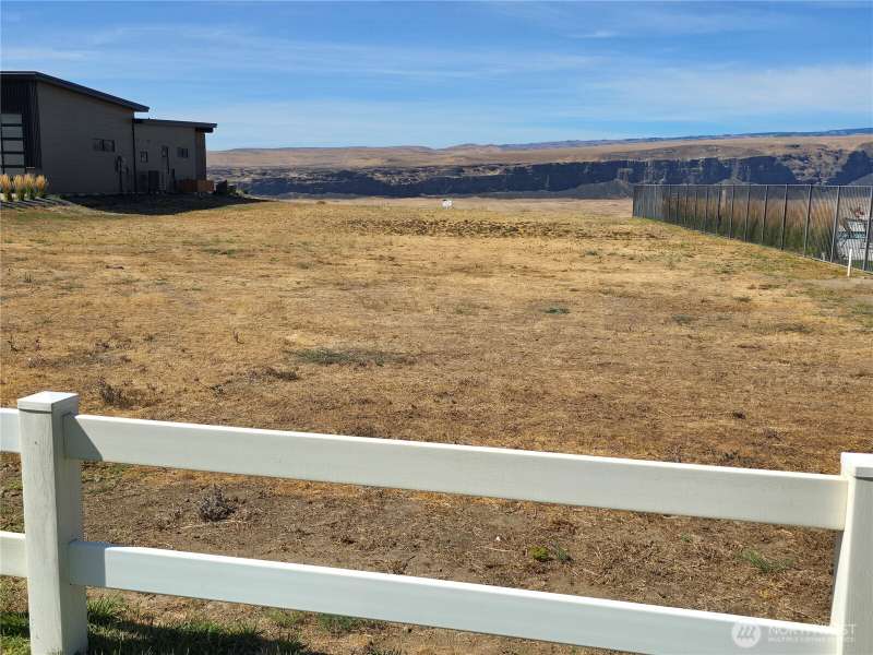 Looking West from above & behind lot. Community Pool & spa next door on right side.