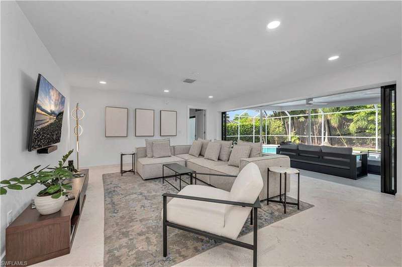 Living room featuring a sunroom, recessed lighting, and concrete flooring