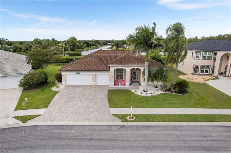 View of front of house featuring stucco siding, decorative driveway, a front yard, and a tile roof