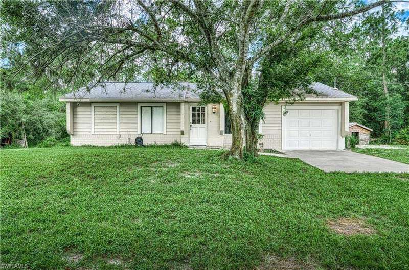 View of front of property with a garage, concrete driveway, a front yard, brick siding, and roof with shingles