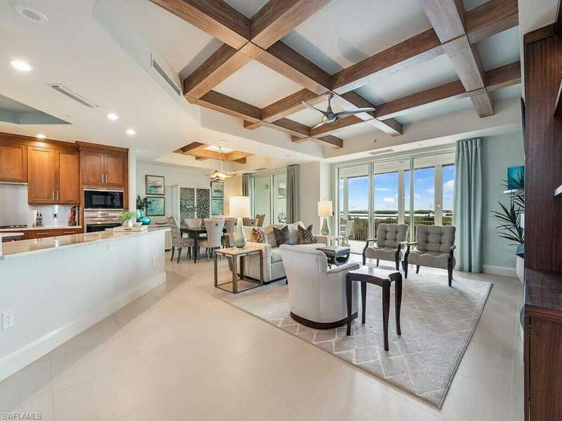 Spacious and open living area with gas fireplace and wood detailing on the ceiling.