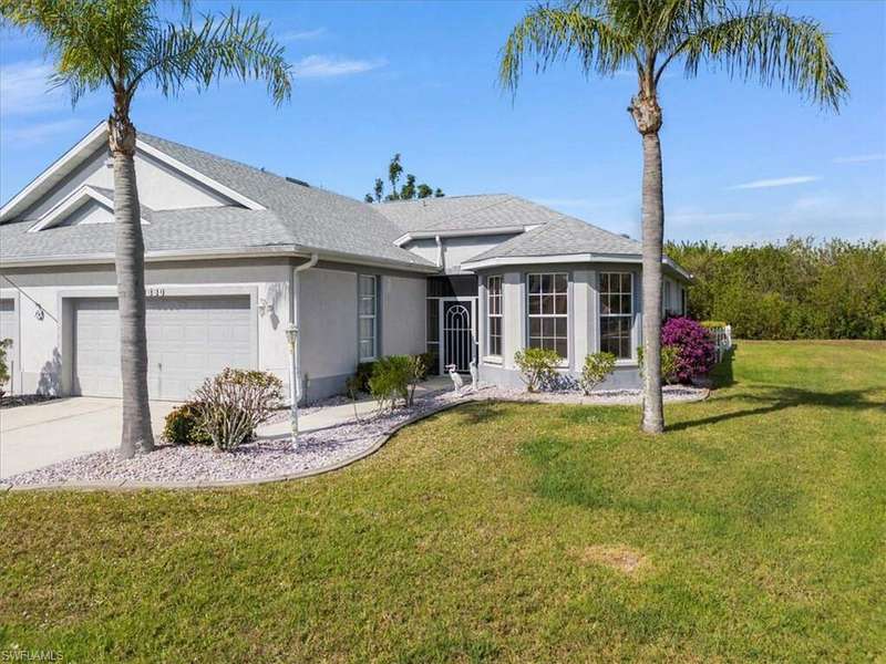 Single story home featuring a garage and a front lawn