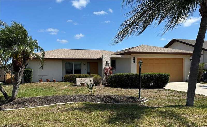 Single story home with stucco siding, concrete driveway, a front yard, and a garage