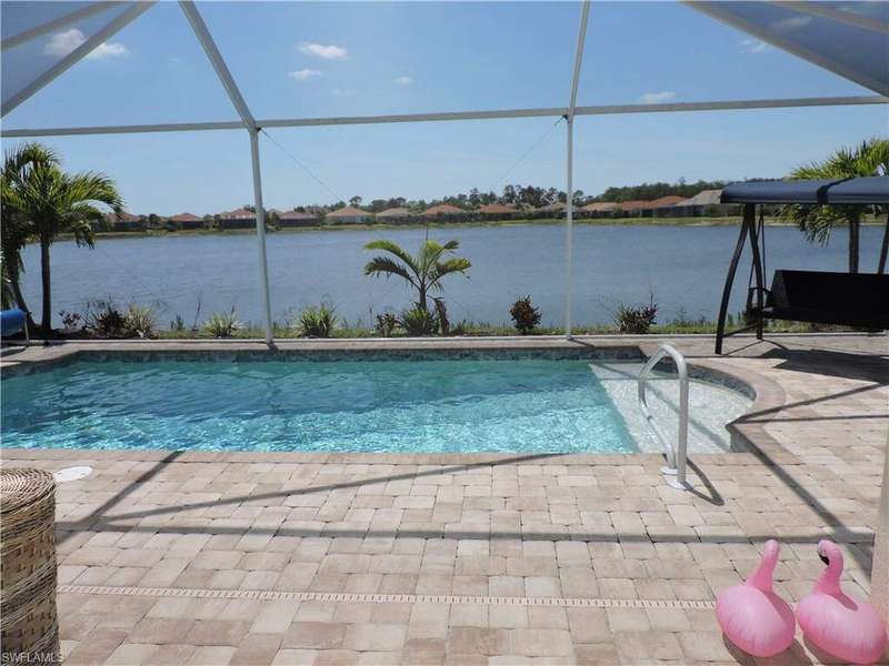 Pool with glass enclosure, a patio, and a water view