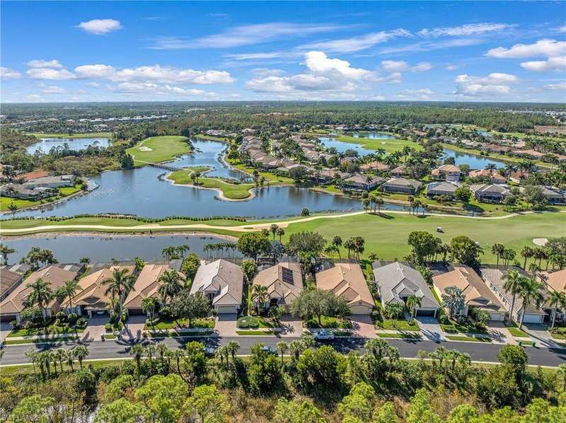 Aerial view of residential area with a local golf course and a large body of water