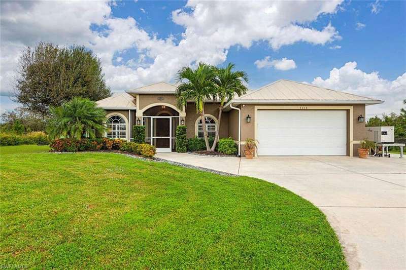 View of front of house with a front yard and a garage